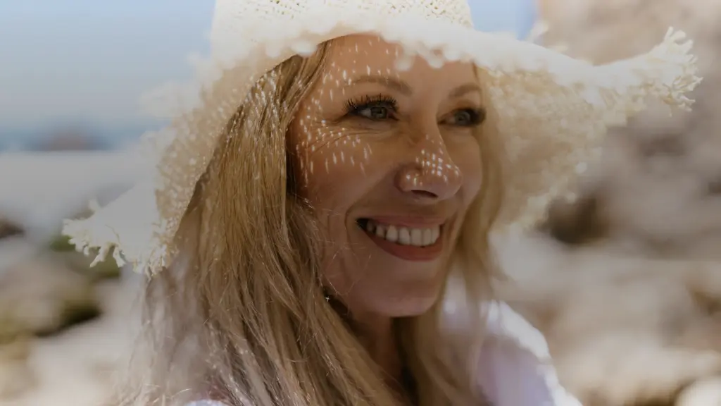 Femme au chapeau de paille souriante sous le soleil